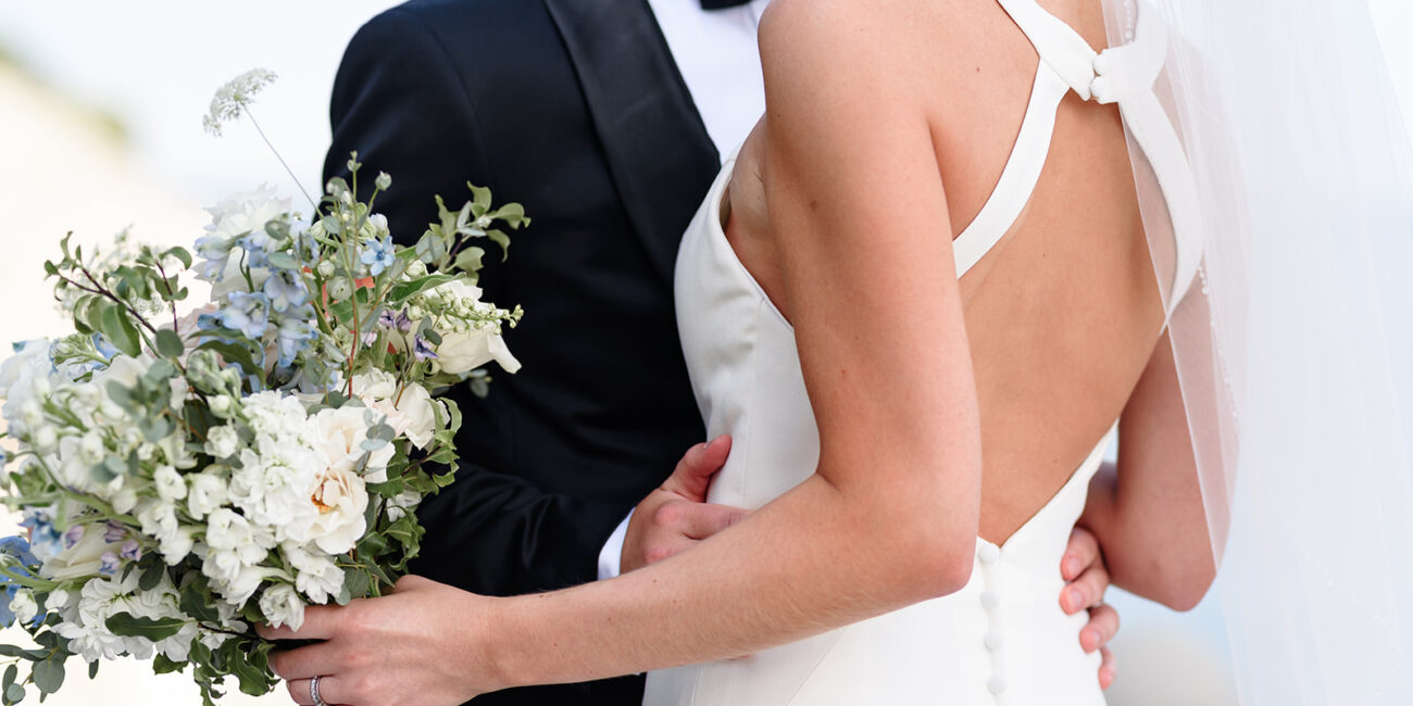 A Burlington, ON wedding photographer captured an intimate moment between a bride and groom in tuxedos as they lovingly hugged each other at Pearle Hotel & Spa in Burlington.