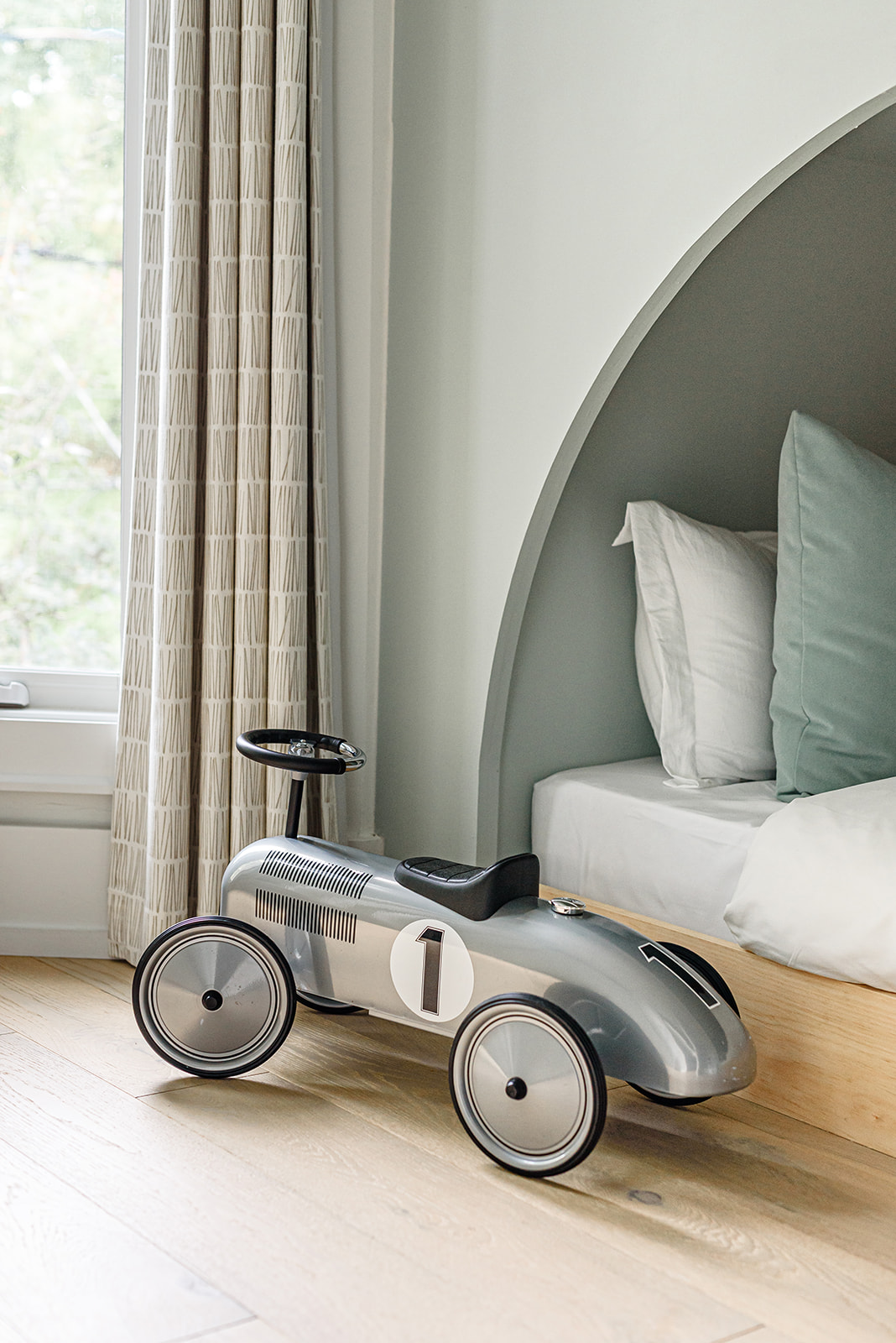 A room with a bed and a toy car.