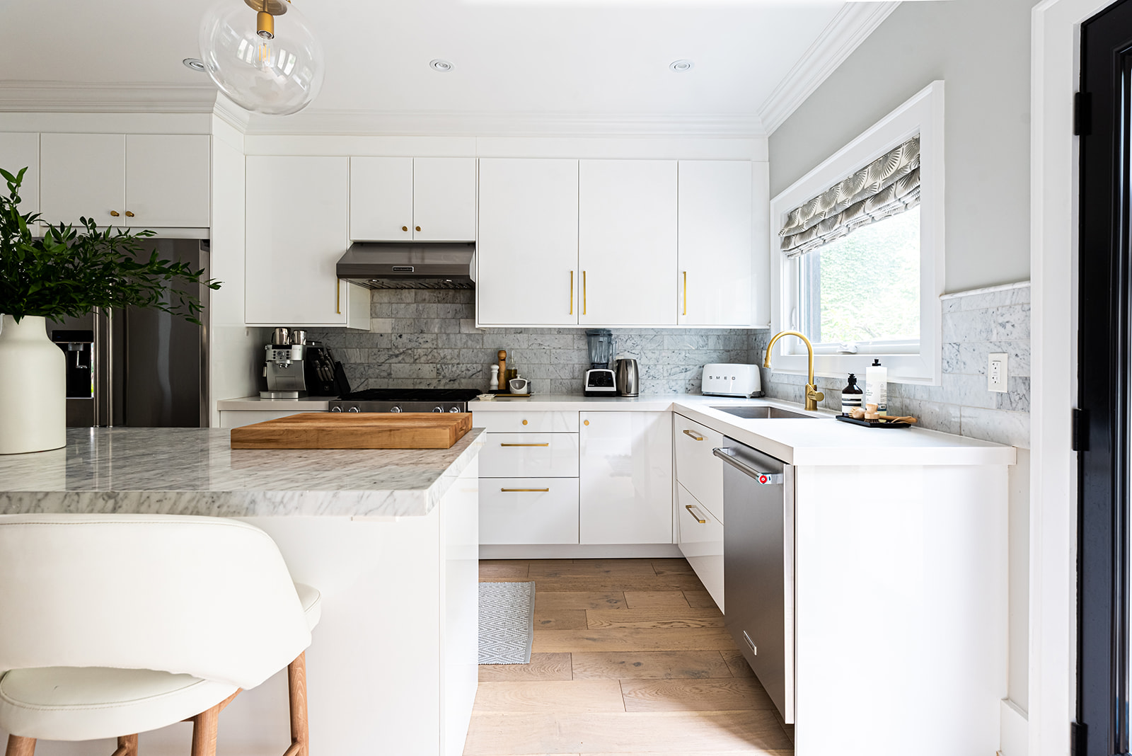 A kitchen with white cabinets and a wooden island.
